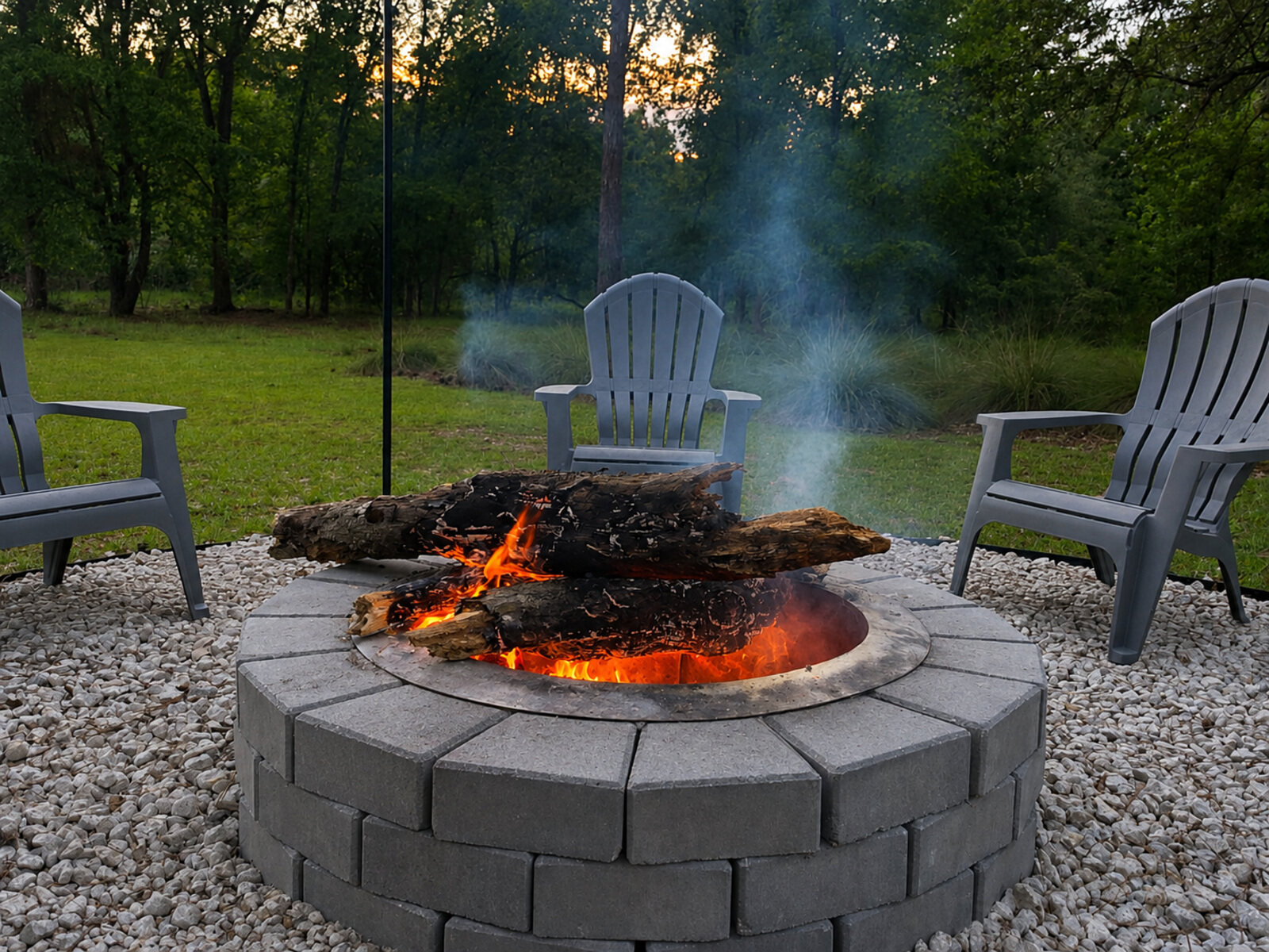 Stone fire pit surrounded by Adirondack chairs