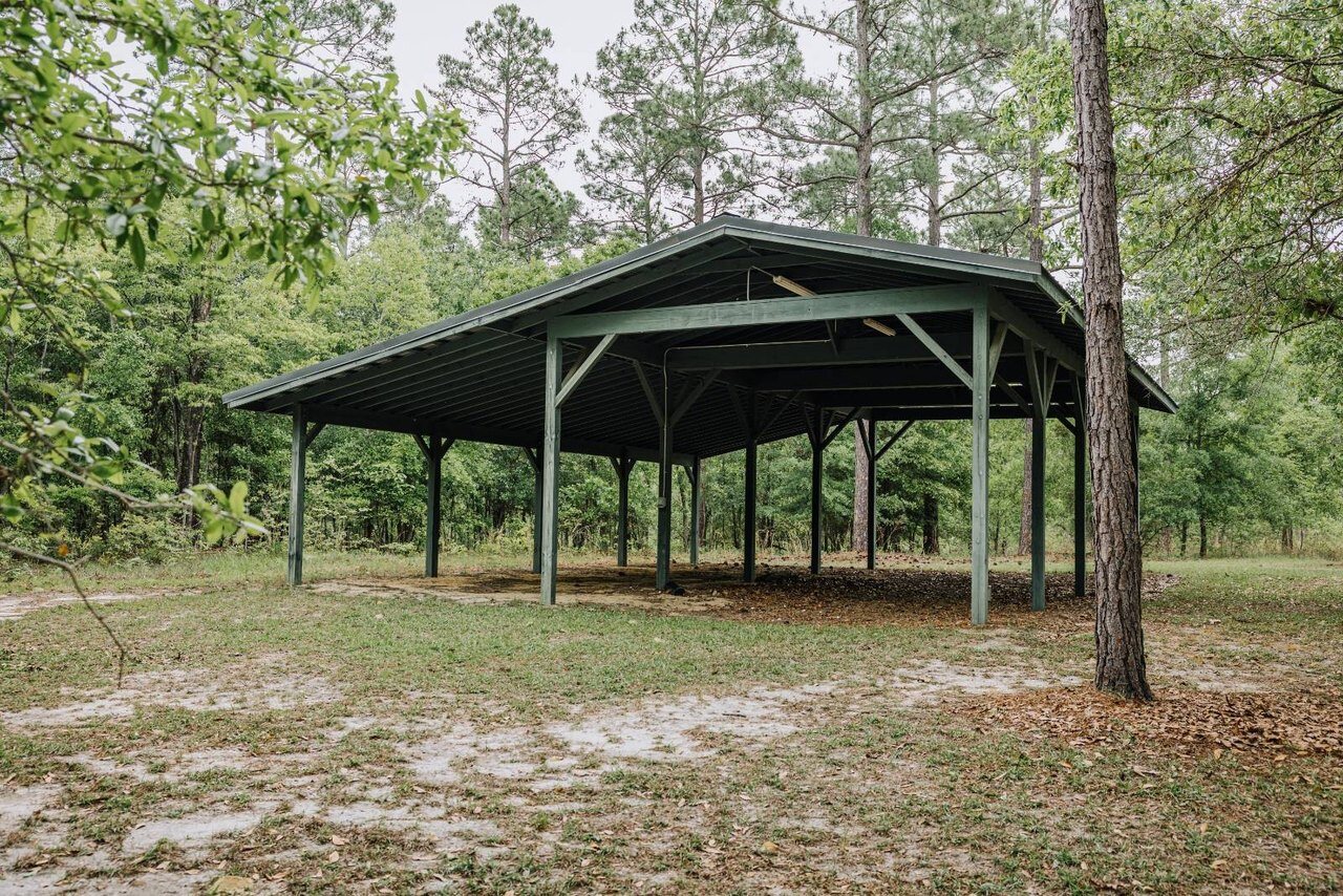 Covered RV and boat trailer shelter on the wooded property